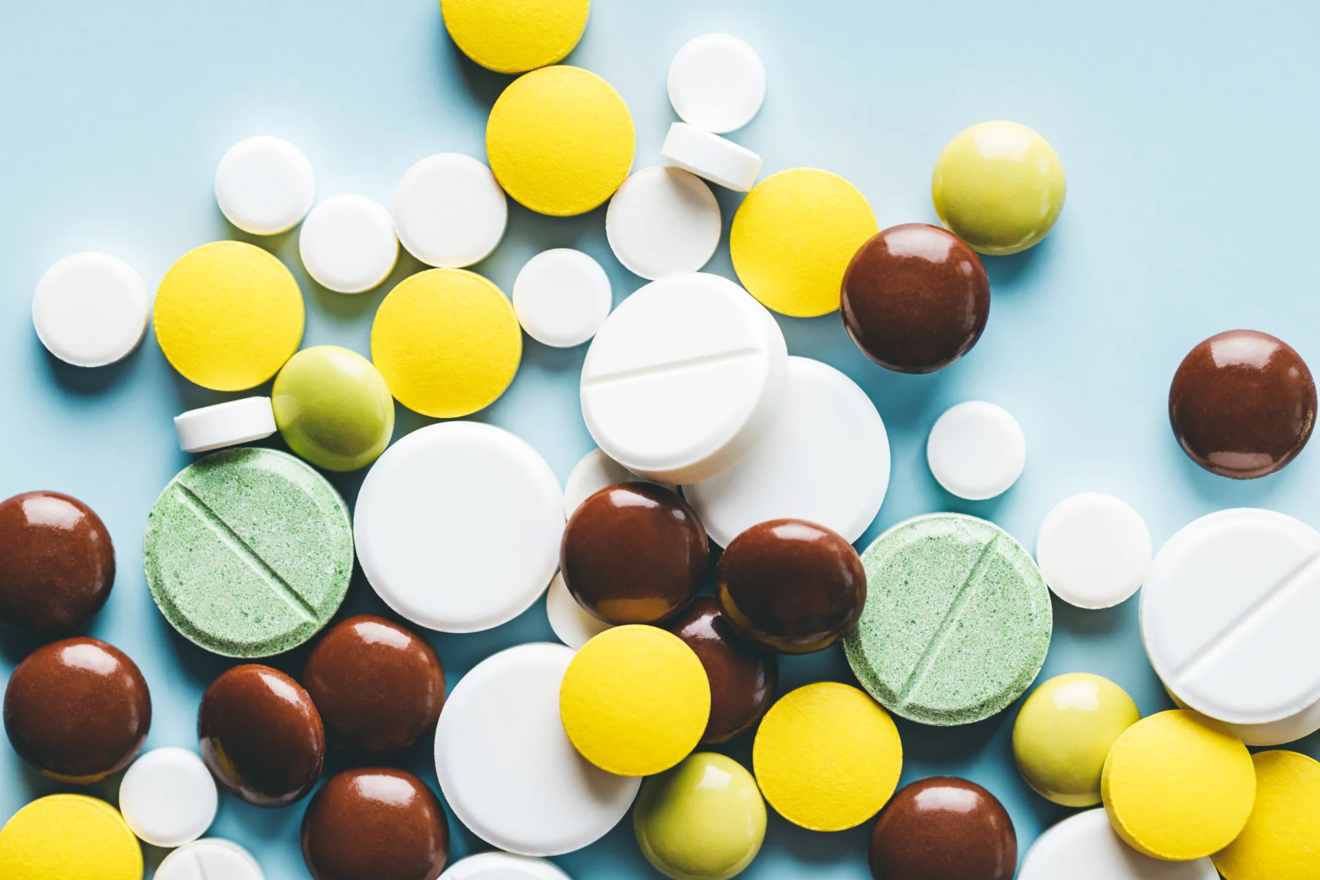 assorted pills and tablets on a blue surface